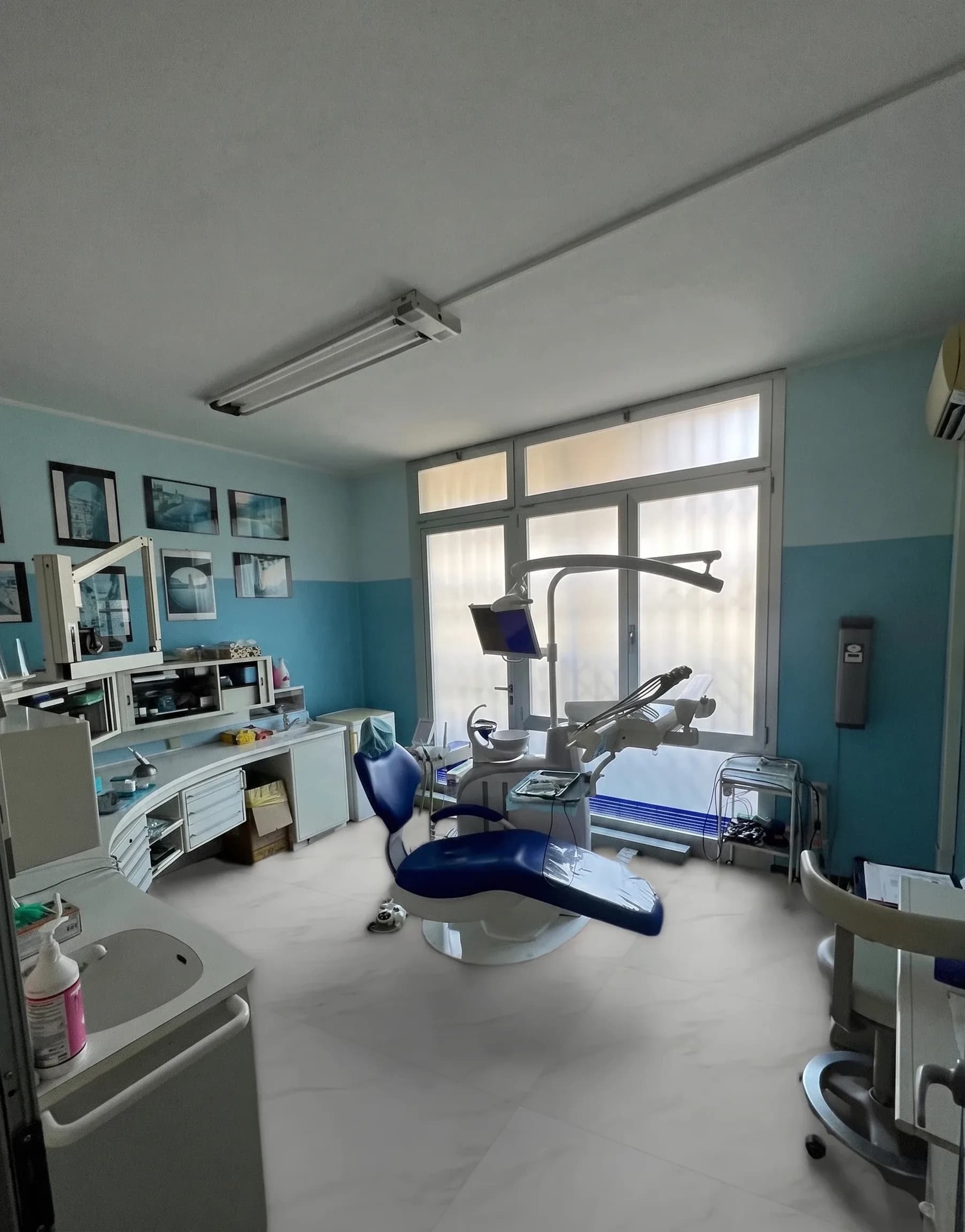 Sala operativa azzurra dello studio dentistico, con riunito e strumentazione